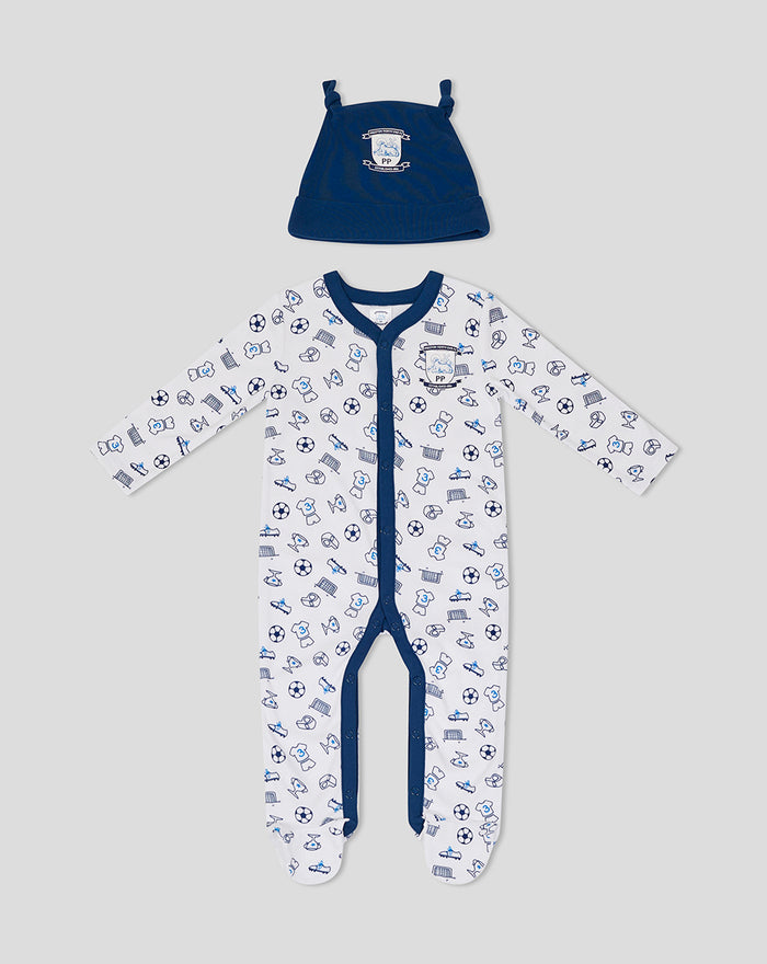 Footed white baby romper with blue sports icons and navy trim, paired with a matching navy hat from the Baby Core Gift Set 1