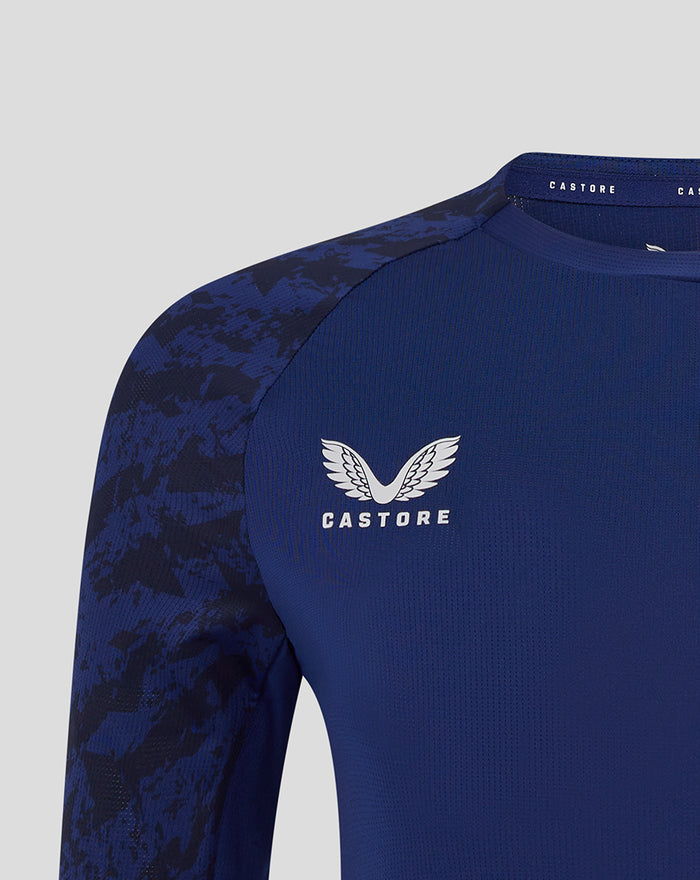 Close-up of shoulder and chest area showing Castore logo and club crest on navy training tee.