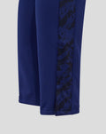 Close-up of junior training knit pant leg in blue with a dark printed side panel.
