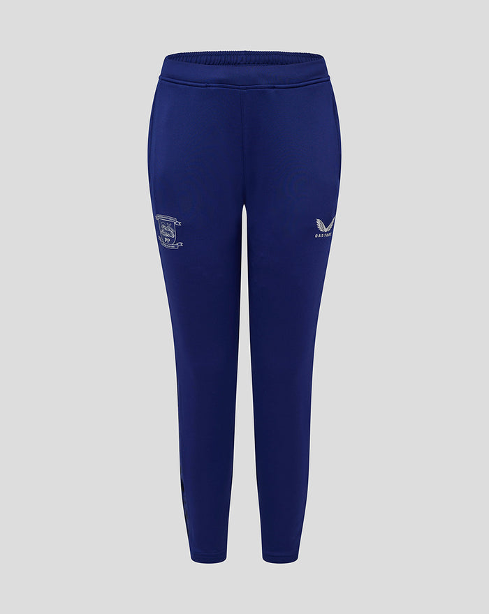 Junior blue training knit pants with a club crest on the left thigh and Castore logo on the right.