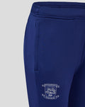 Close up of navy training pants showing an elastic waistband and a crest on the leg.