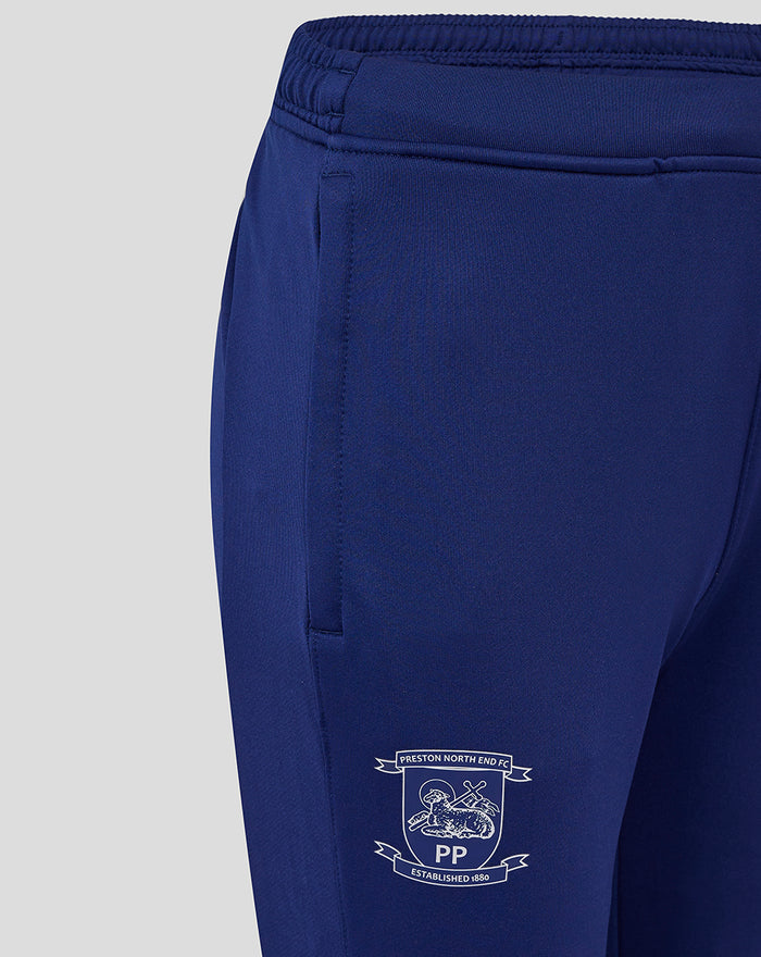 Close up of navy training pants showing an elastic waistband and a crest on the leg.