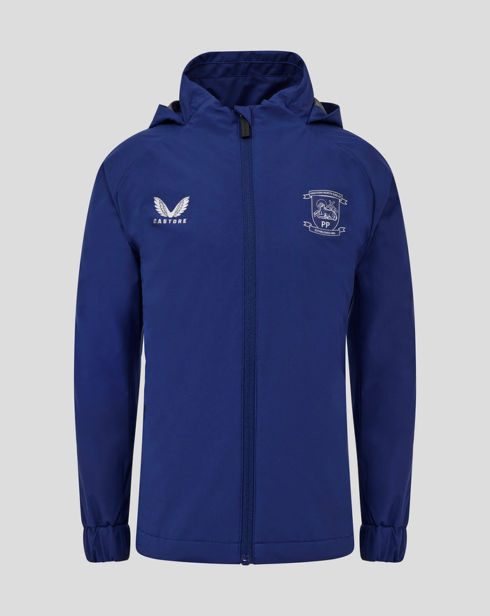 Front view of blue junior training packable hooded shower jacket with central zip and chest crest.
