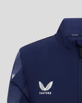 Close crop of navy junior matchday jacket showing high collar and full zip with Castore branding.