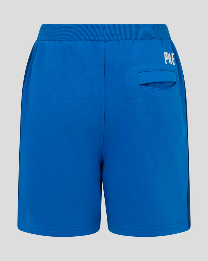 Front view of blue junior shorts showing crest patch on left leg and white side stripe