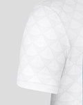 Close-up of the white junior home shirt sleeve showing the geometric texture.