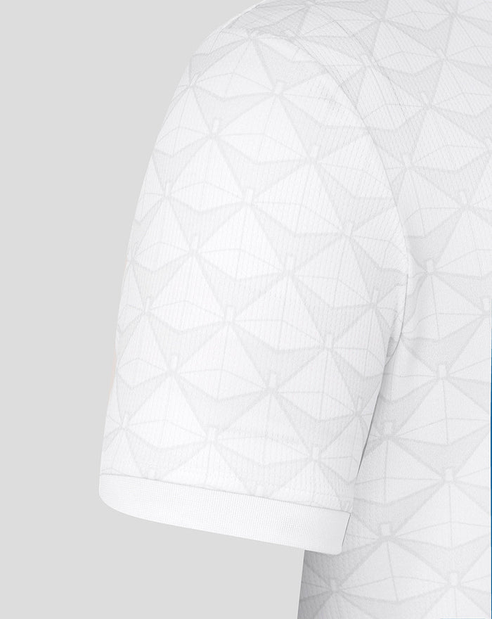 Close-up of the white junior home shirt sleeve showing the geometric texture.