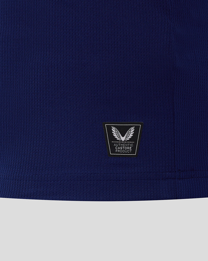 Close-up of dark blue jersey fabric showing an Authentic Castore Product patch with winged emblem