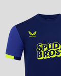 Dark blue junior away shirt with neon yellow Spud Bros graphic and Castore logo on the chest