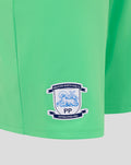 Close-up of Preston North End FC crest patch on bright green goalkeeper shorts.