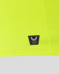 Close-up of neon lime fabric with a small black Authentic Castore Product badge near the hem.