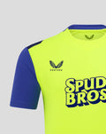 Shoulder and chest detail of neon yellow shirt with crest and Spud Bros logo on front