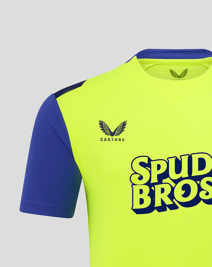Shoulder and chest detail of neon yellow shirt with crest and Spud Bros logo on front
