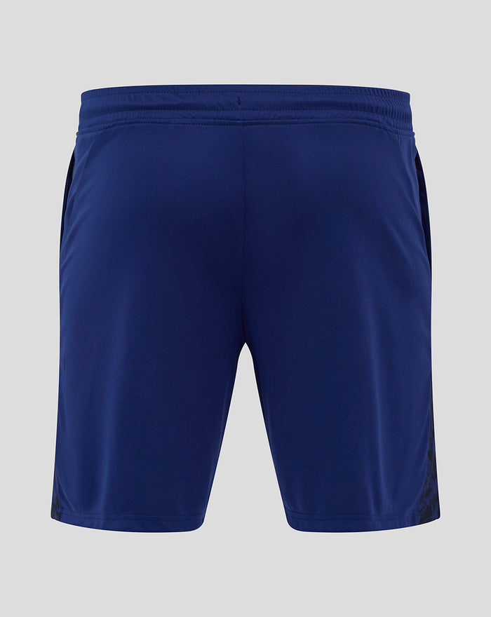 Back view of navy junior training shorts featuring a patterned side panel and club crest on the left leg.