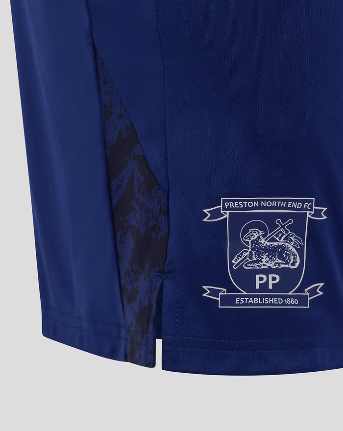 Close up of navy junior shorts showing Preston North End crest on the lower right with a camo side panel.