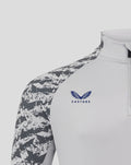 Shoulder and chest view of the midlayer showing camo sleeves and Castore logo with club crest on chest.