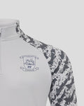 Close up of men's grey training midlayer featuring a white front panel with club crest and camo patterned sleeves.