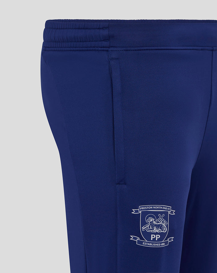 Close up of navy training knit pants showing contrast side panel and crest logo on the leg