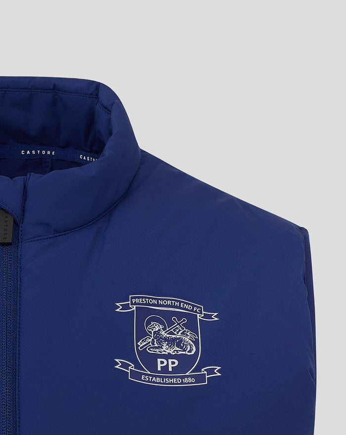 Close up of blue training gilet chest area showing crest and Castore branding at the neck.