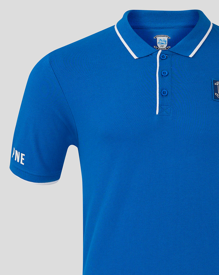 Blue Preston North End polo with white piping on collar and placket, badge on left chest and silicone branding on sleeve.