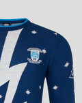 Chest detail of navy Christmas jumper with large white bolt pattern and a crest patch on the left chest.