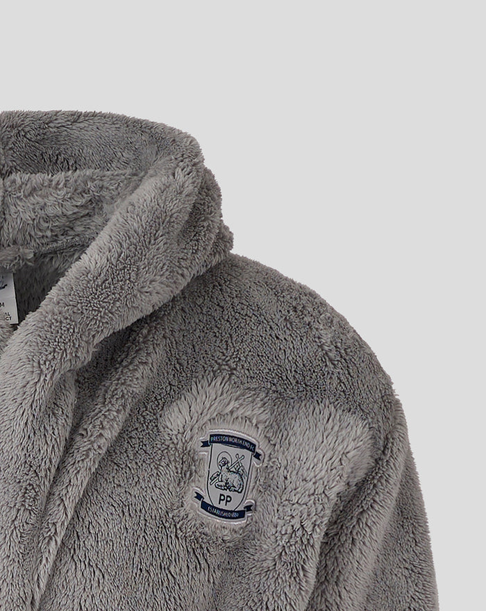 Close up of grey plush dressing gown showing the crest patch on the chest