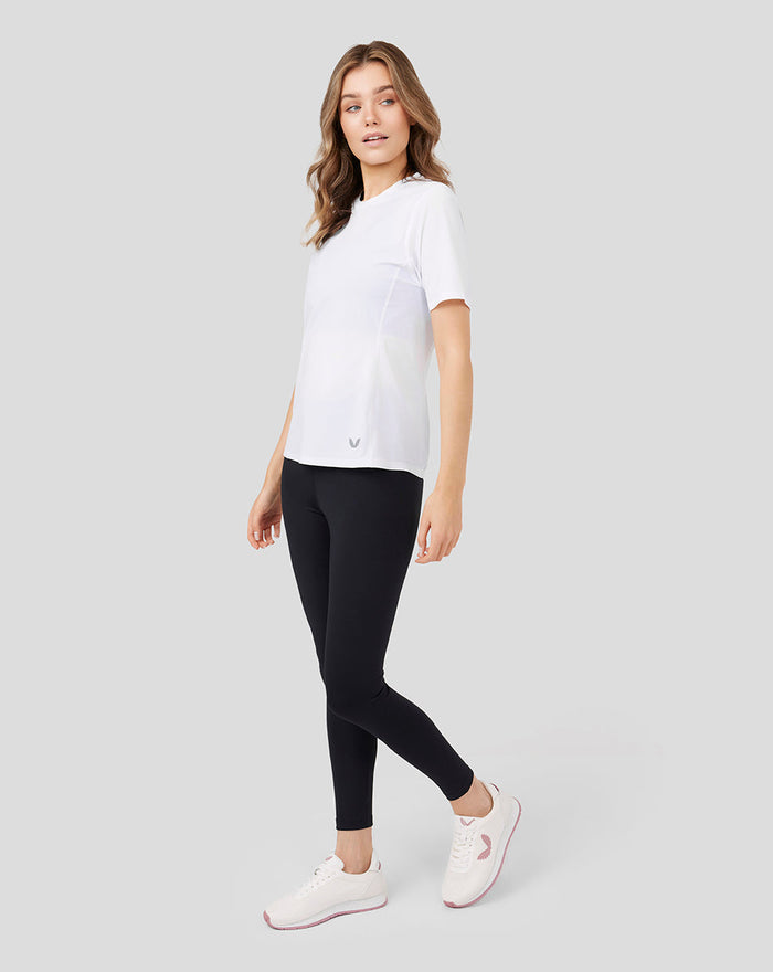 Front three quarter view of a model wearing a white Women's Metatek Training T Shirt with black leggings.