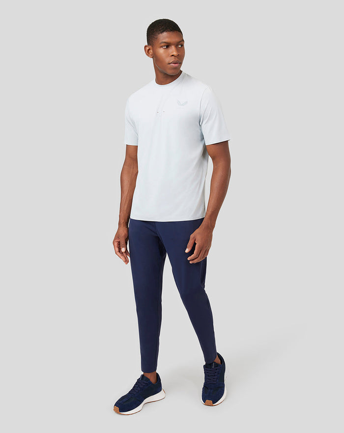 Model wearing Mist Metatek Training T-Shirt in pale gray with navy athletic pants