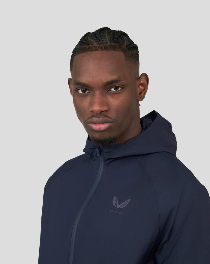 Close up of model wearing navy Metatek Flyweight Jacket showing high collar and chest logo