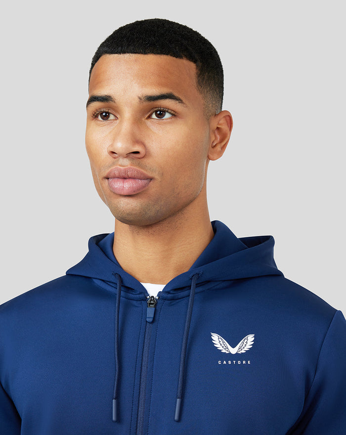 Model wearing blue Peacoat Scuba Zip Through Hoodie with white chest logo