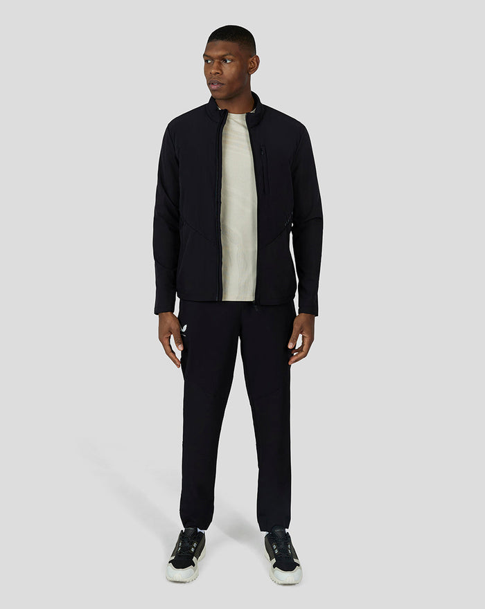 Male model wearing black Carbon Capsule Hybrid Active Jacket with zipped front and stand collar; beige inner layer visible