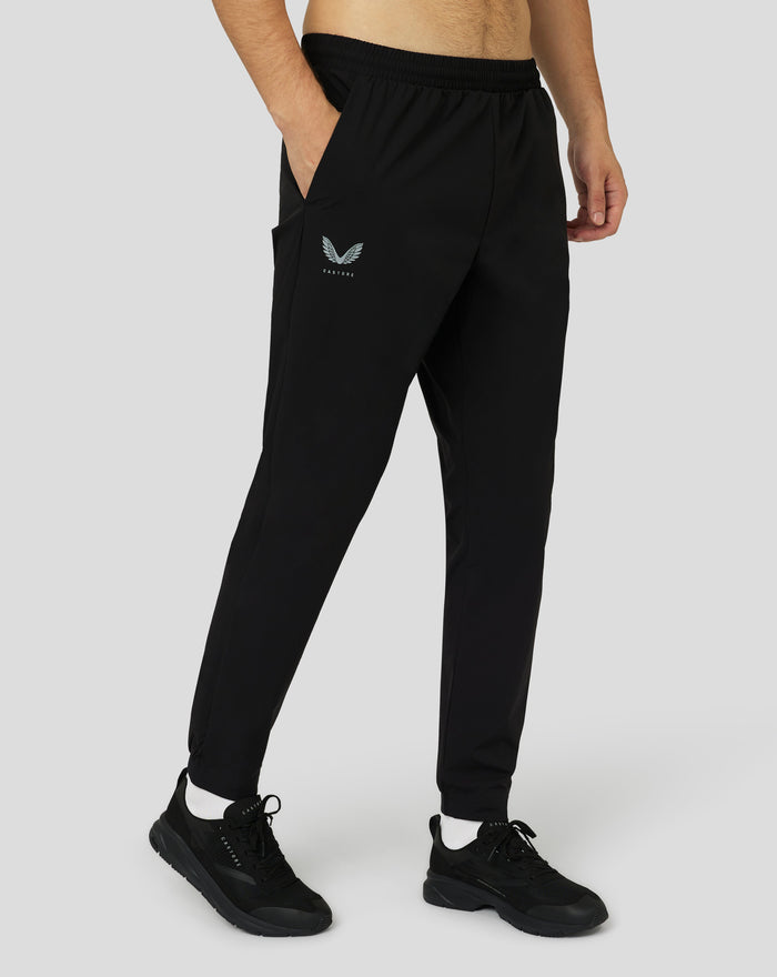 Male model in black Protek woven joggers with a small Castore logo on the leg and an elastic drawstring waistband