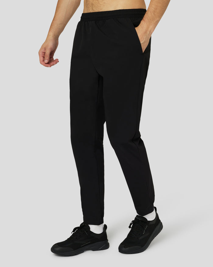 Back view of man in black Protek woven joggers with Castore emblem on rear leg
