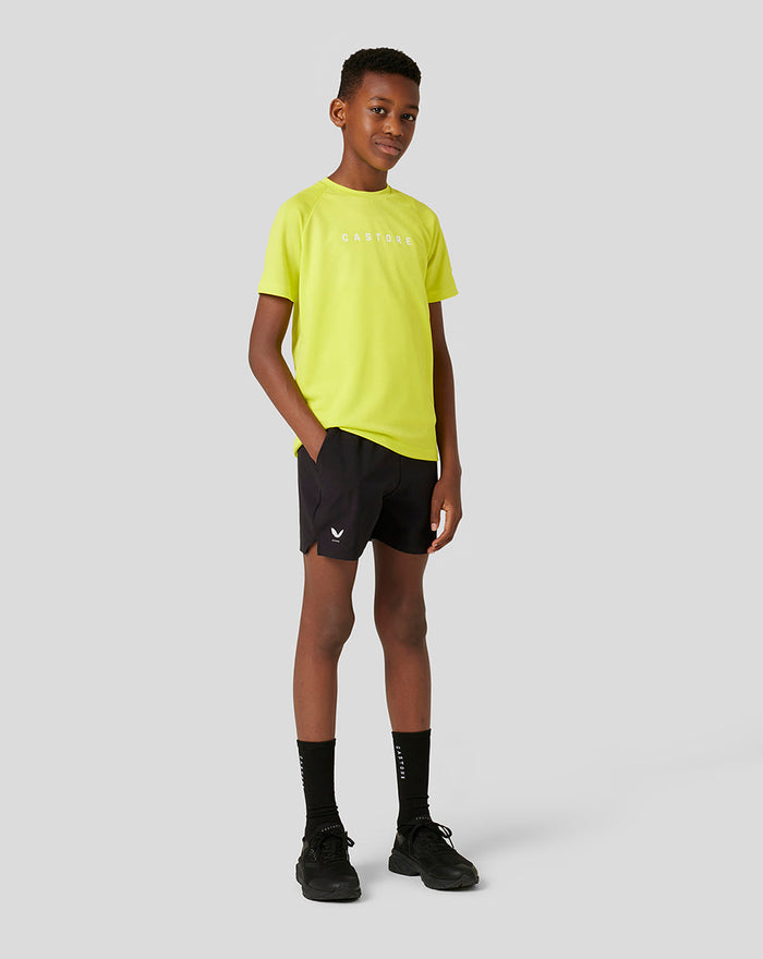 Young model wearing black junior woven shorts with side pockets and a white Castore logo on the left leg