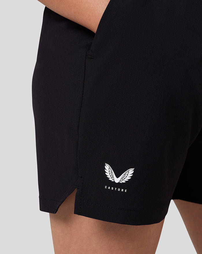 Black junior woven shorts with a white Castore wing logo at the hem and an open side pocket