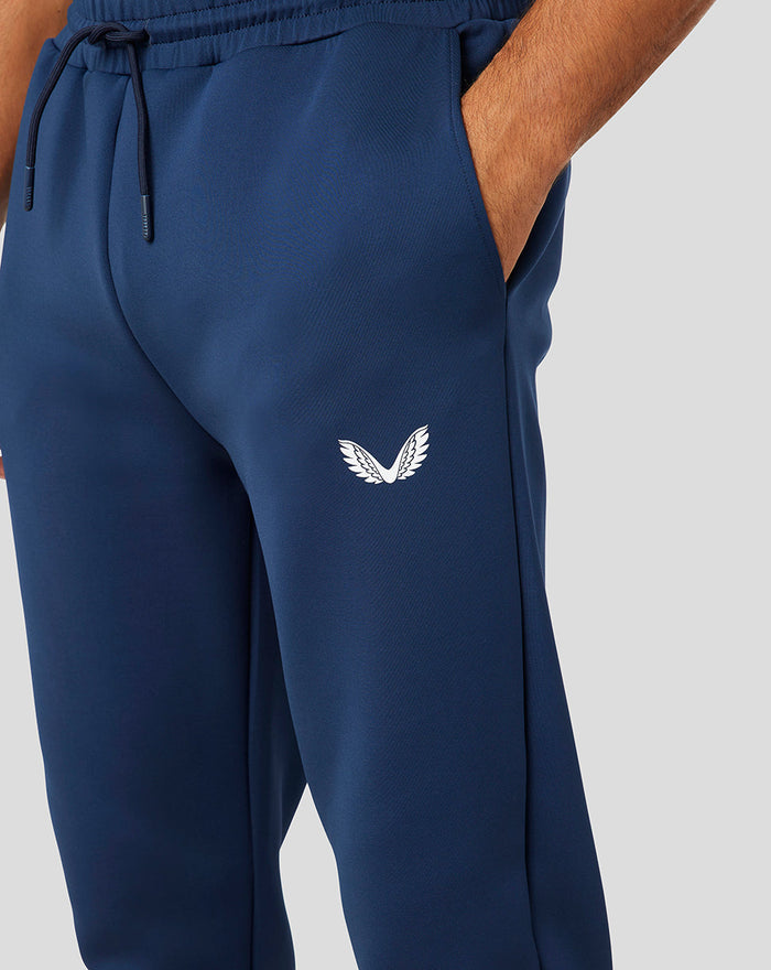 Side view of navy Peacoat Scuba Jogger with white wing logo on the thigh and streamlined fit